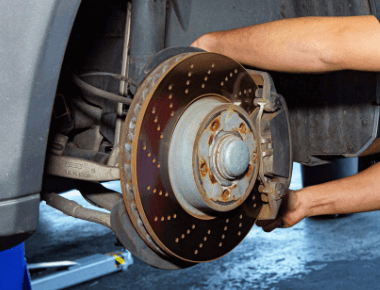 Brake service and repair; A John's Auto Pros technician working on the brakes of a car