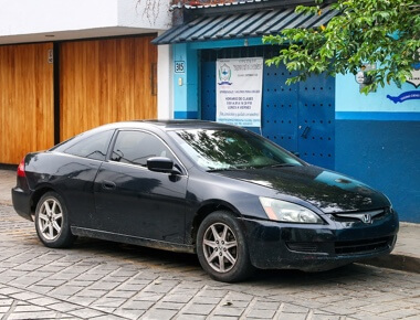 foreign vehicle service and repair in Escondido CA image of black 4 door Honda Accord parked outside of blue and wooden store front